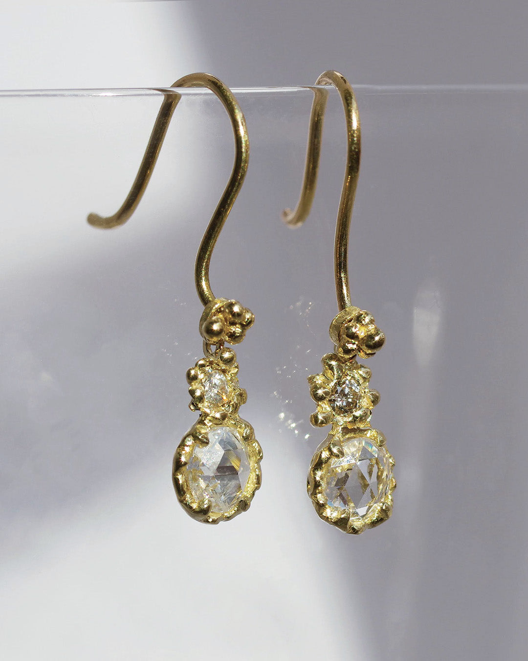 グラスにかけられたローズカットダイヤモンドのフックピアス