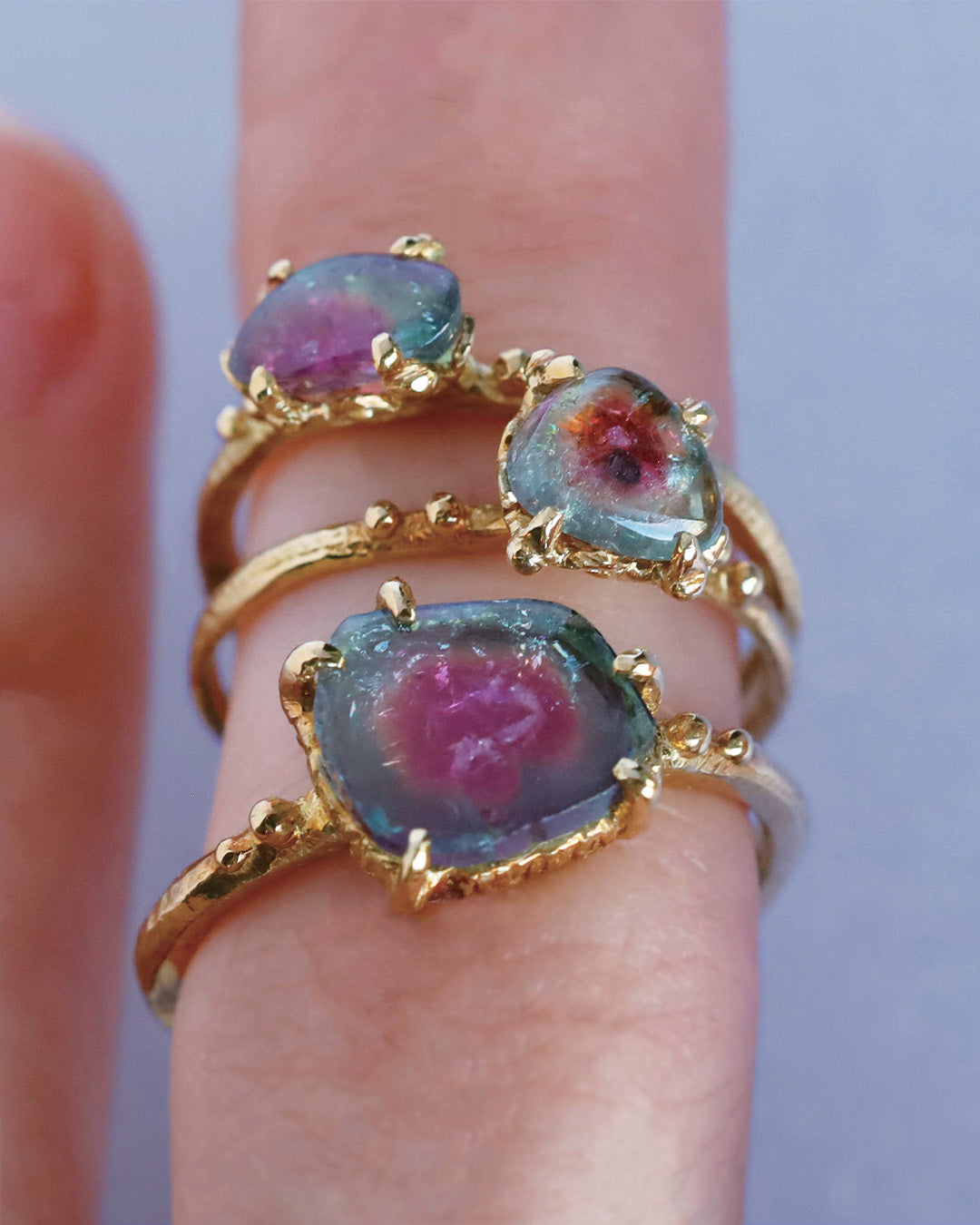 3つの大きさの違うバイカラートルマリンリングを一本の指に着用している
