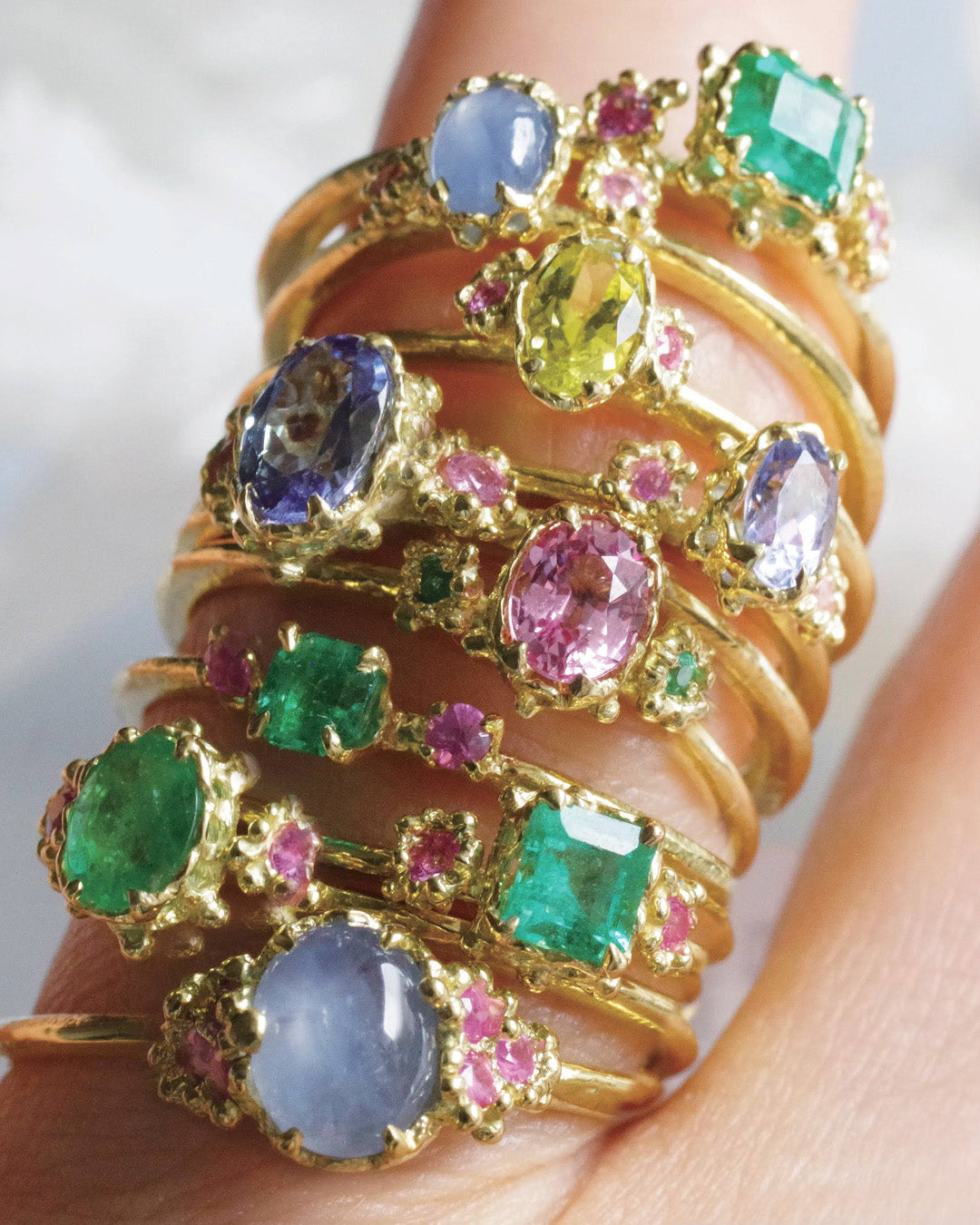 エメラルドやサファイヤなどの華やかなリングを一本の指に着用している